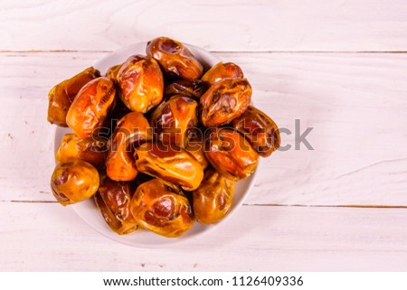 Date fruits on a white wooden table. Top view