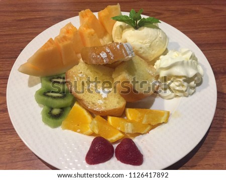 Relax time with honey toast served with melon, orange, kiwi, ice cream, whipping cream and also small mint leave. Happy time comes with delicious sweet.