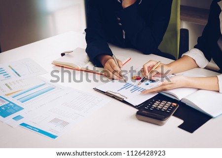 Business woman and partner hand pointing at finance chart for planning about marketing, tax, accounting, statistics and analytic research concept. Royalty-Free Stock Photo #1126428923