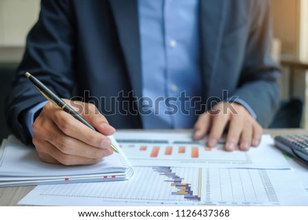 Businessman analysis maketing plan, Manager calculate financial report and graph chart.  Business, Finance and Accounting concepts