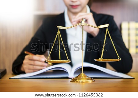 lawyer judge reading documents at desk in courtroom working on wooden desk background. gavel  golden Weight. and soundblock of justice 