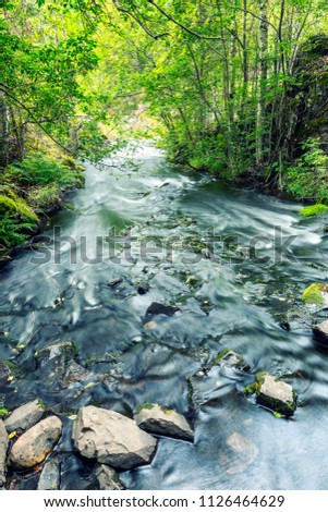 A powerful stream of water among the stones, a beautiful waterfa