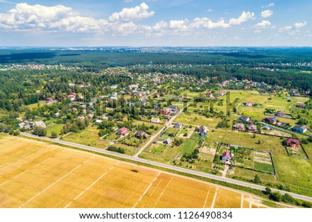 Aerial drone view of wheat fields and plantation. Countryside, rural landscape with cloudy sky