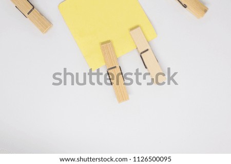 Empty paper stickers suspended on clothespin