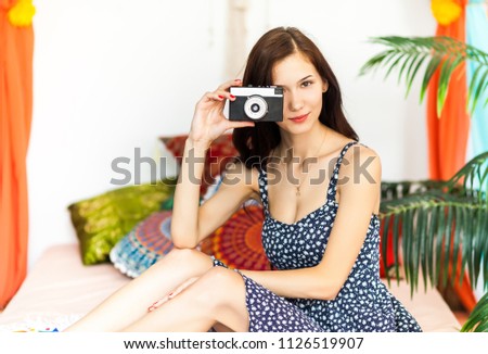 Beautiful woman Photographer making pictures with retro hipster camera having fun at the vacation. Summer lifestyle