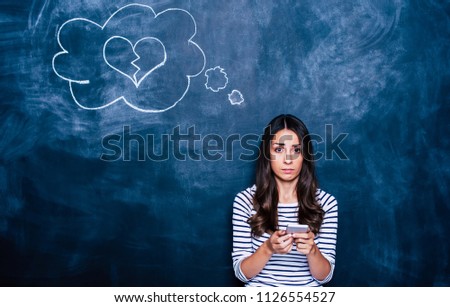 Bad message. Young woman with phone in hands and crashed heart sign in cloud over her