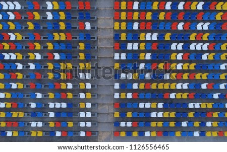 Multicolored seating in the stadium, view from the sky. Aerial photography, background.