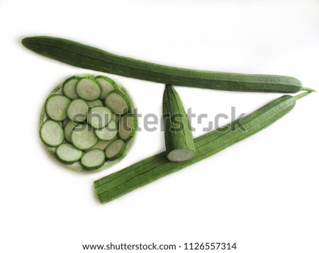 Fresh zucchini, sliced in a bowl and Green vegetables is arranged in the shape of “A” on white background. ("A" means vitamin A in vegetables)
                               