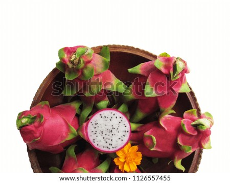 Fresh dragon fruit is in a wooden tray, with a half cut dragon fruit and yellow flower in the middle, on white background.
                             
