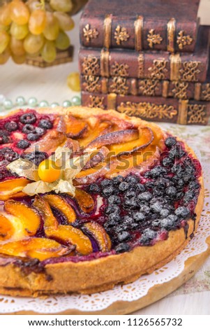 Berry pie, a tart filled with jam made from black currants, in glass form a gray background. Selective focus, close-up