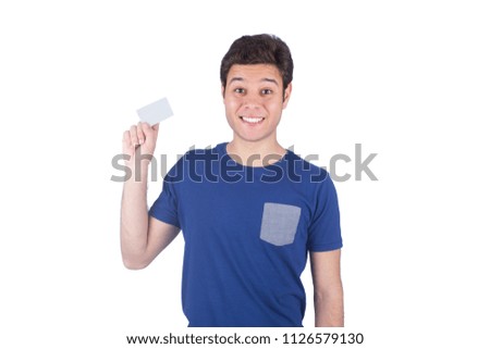 Portrait of a handsome young man wearing a t-shirt, holding a personal card in his hand and smiling, isolated on white background.