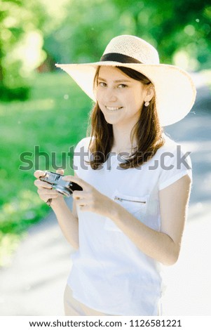 A girl with a camera in her hands, with a hat on her head