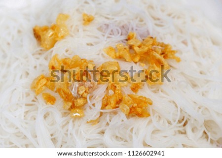 Closeup shot of deep fried garlic topped on white vermicelli noodle, a kind of Thai cuisine, food photography