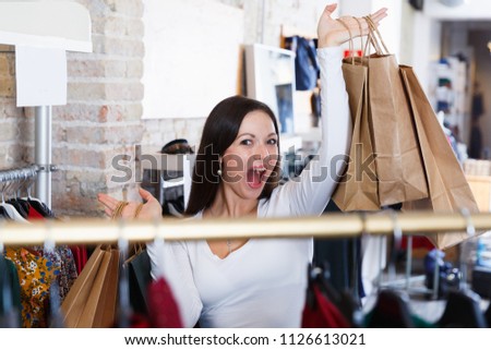 Portrait of young woman standing happinnes with bags  in  clothes shop
