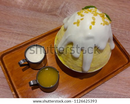 Kakigori mango  Thailand Shave Ice Patbingsu or Bingsu Frozen dessert on wooden table in cafe shop.