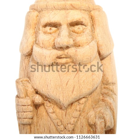The figure of the good Wizard carved from beech with a staff and a scroll in hands. Old decorative toy. Portrait. Isolated on a white background