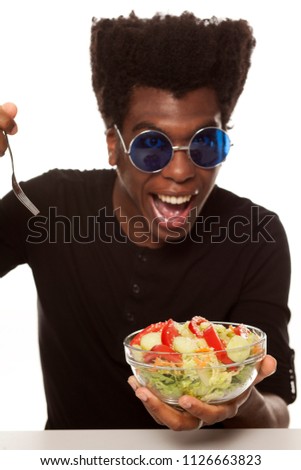 young handsome afro american guy eat salad isolated on white background. healthy food concept