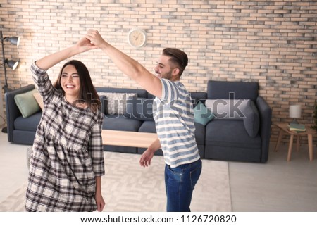 Beautiful young couple dancing indoors