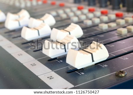 detail of a music mixer desk with various knobs