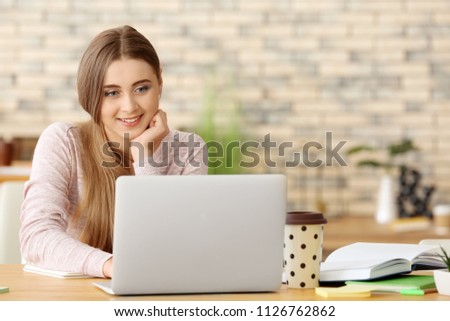 Teenage girl with laptop studying indoors