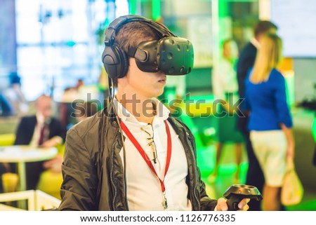Young man playing video games virtual reality glasses. Cheerful man having fun with new trends technology - Gaming concept.