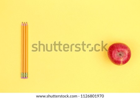 Pencils and apple on a yellow background. Back to school concept. Horizontal