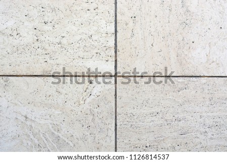 View on a block of four travertine tiles in a square design to be used as construction material to be used for floors and patios.
Texture and structure very well visible.