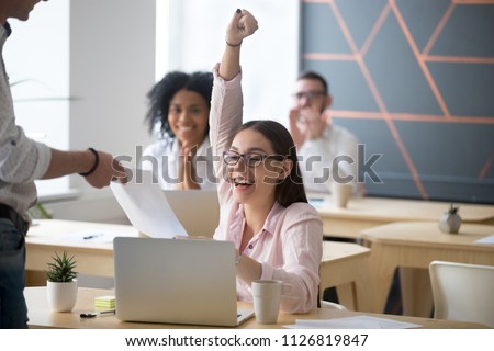 Excited female student screaming with happiness, getting high-evaluated exam sheet, satisfied female worker showing best work results, receiving new position promotion letter. Concept of reward