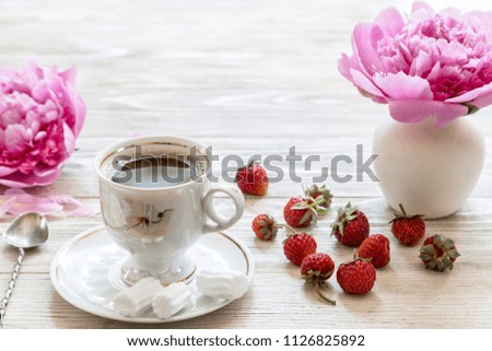 Coffee with marshmallow and strawberries on a light wooden background.