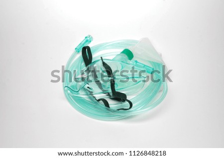 Medical oxygen face mask with tubing on white background. Selective focus.