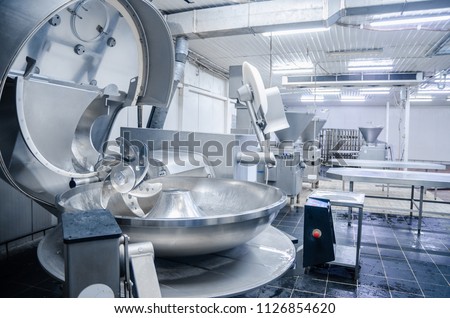 Cutter. Industrial cutter for grinding meat. Factory for the production of sausages and meat delicacies. Background. Royalty-Free Stock Photo #1126854620