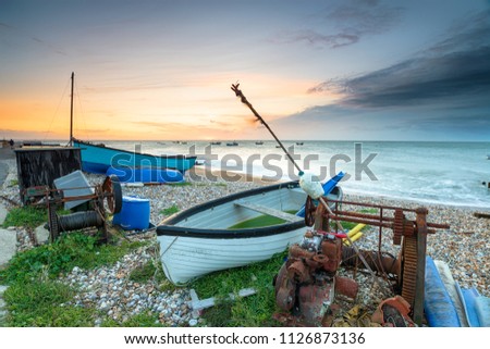 Stormy sunrise over boats on the beach at Selsey Bill on the Sussex coast