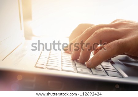 Man's hands typing on laptop keyboard Royalty-Free Stock Photo #112692424
