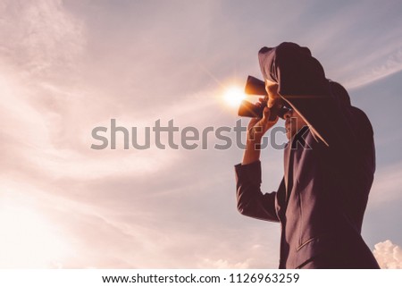 Asian man Hand Holding Binoculars / looking / watching using Binoculars with copyspace,Concept of The pursuit of profitable business in the future.