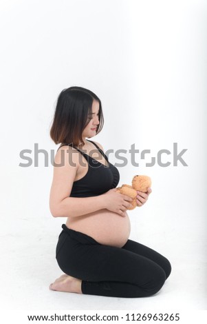 Portrait of asian pregnant woman on white background,thailand people,teddy bear doll in her hand