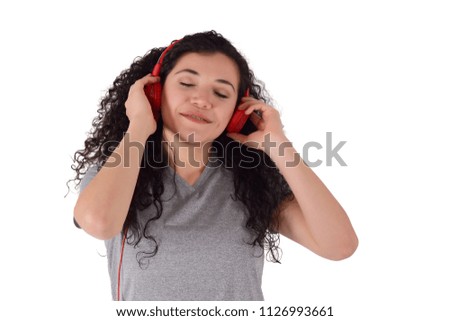 Young latin woman listening music in headphones. Isolated white background.