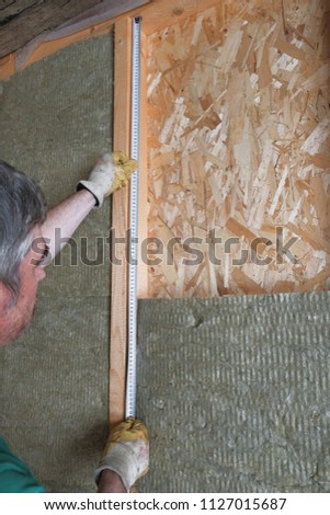 worker insulates a country house of mineral wool