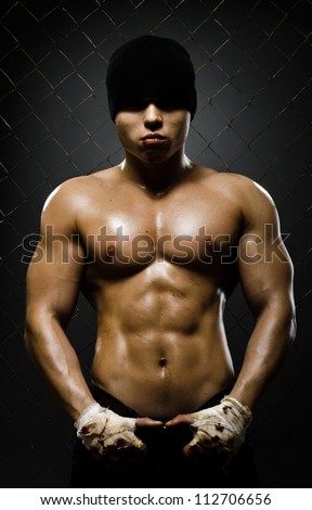 vertical photo  muscular young  guy street-fighter,  aggression look, hard light