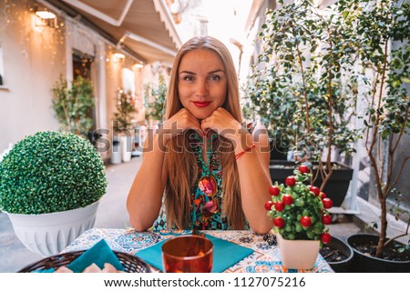 Beautiful girl having lunch in a street cafe in Italy.