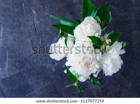 Top view Fresh bouquet of white peonies on dark black stone background. Wedding flowers. Card Concept. Selective focus. Copy space for text