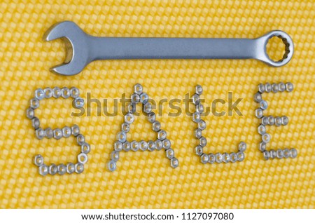Banner with the wrench and word "sale" from iron nuts against the background of honeycombs.