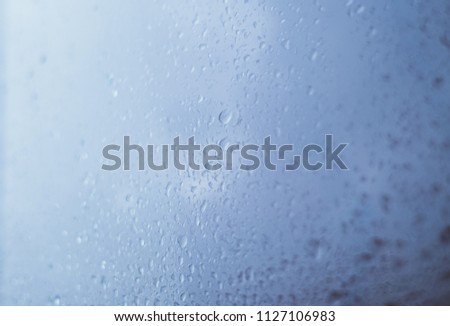 Macro view of raindrops on a window. Summer bad weather. Instagram. Wet glass full of little drops. Front view. Copy space. Background. 