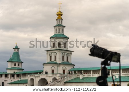 Camera on a tripod against the backdrop of architecture
