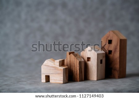 many toy wooden house block on grey leather background