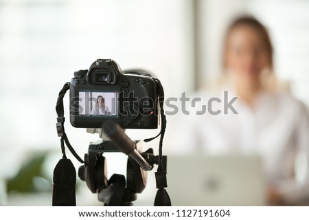 Professional dslr digital camera filming live video blog interview or vlog of woman vlogger coach giving business class or presentation training people online, making videoblog and vlogging concept Royalty-Free Stock Photo #1127191604