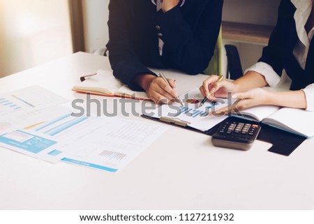 Business woman and partner hand pointing at finance chart for planning about marketing, tax, accounting, statistics and analytic research concept. Royalty-Free Stock Photo #1127211932