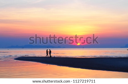 Romantic silhouette couple watching  beautiful sunset on the beach at  Nathon Beach  Samui Thailand