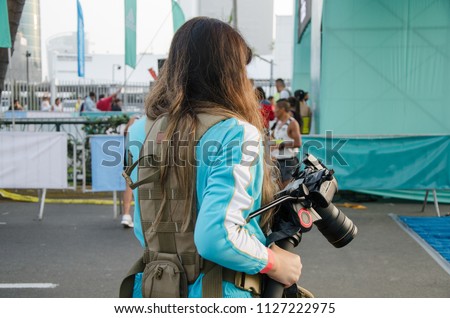 Young female sports photographer ready to take pictures of the marathon