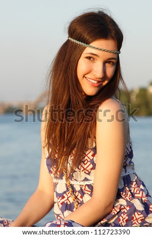 Outdoors summer portrait of beautiful young teen girl on the river bank