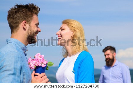New love. Ex partner watching girl starts happy love relations. Ex husband jealous on background. Couple in love dating outdoor sunny day, sky background. Couple with flowers bouquet romantic date. Royalty-Free Stock Photo #1127284730